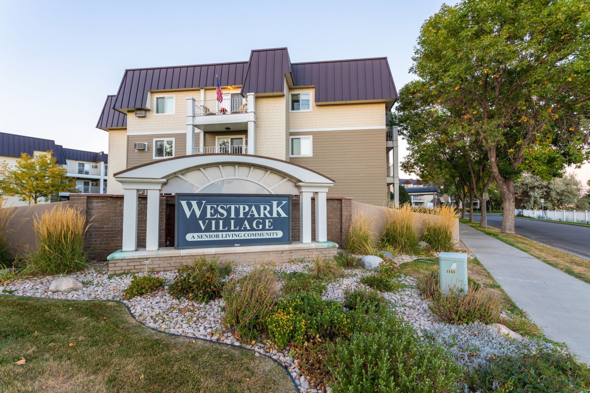 An apartment building with a sign reading 'Westpark Village' in a well-landscaped residential area.