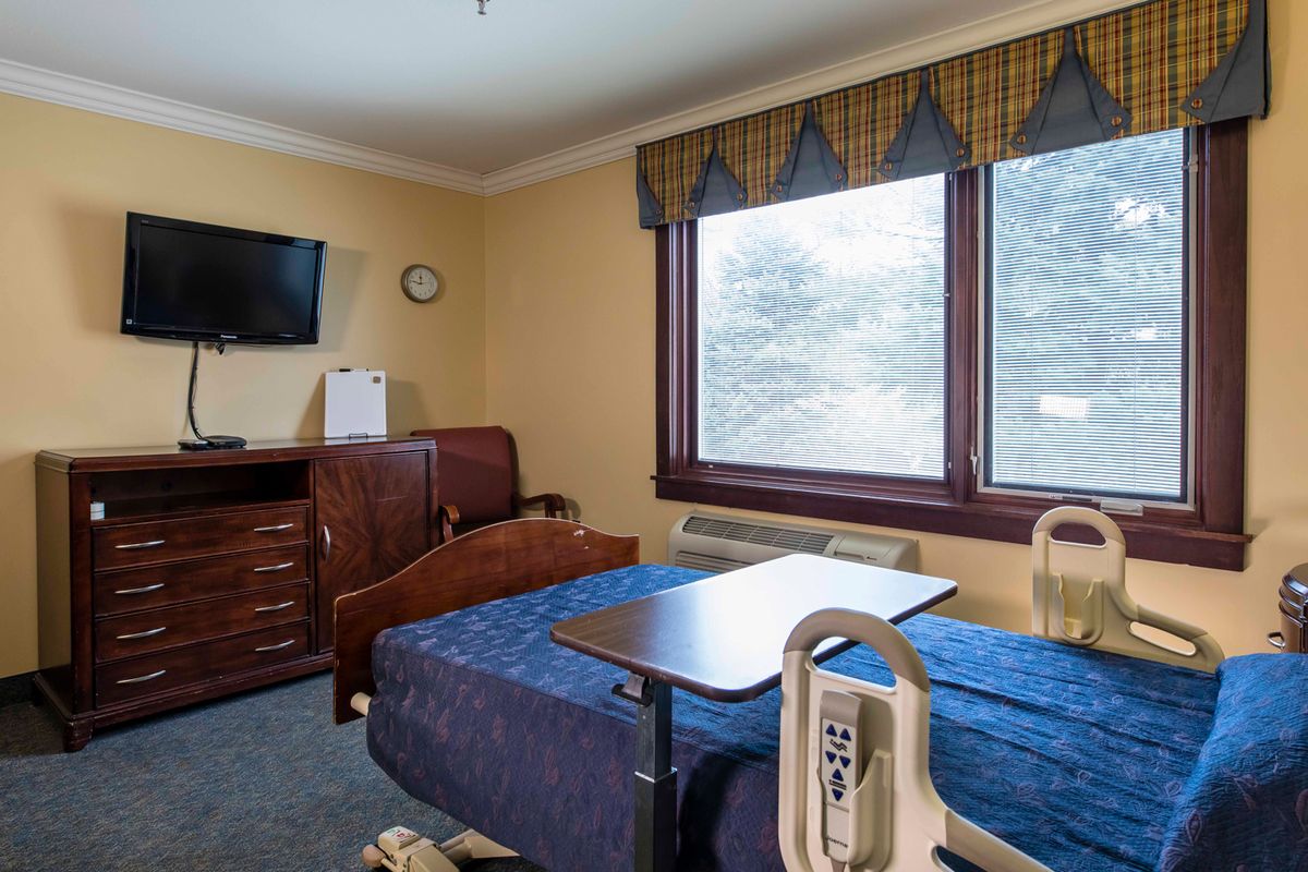 A hospital room with a bed, medical equipment, and a TV.