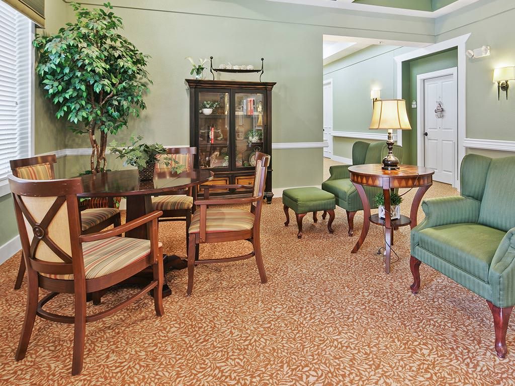A traditional living room with wooden furniture and green accents.