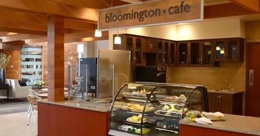 Interior of Bloomington Cafe with a display case showing various bakery items.