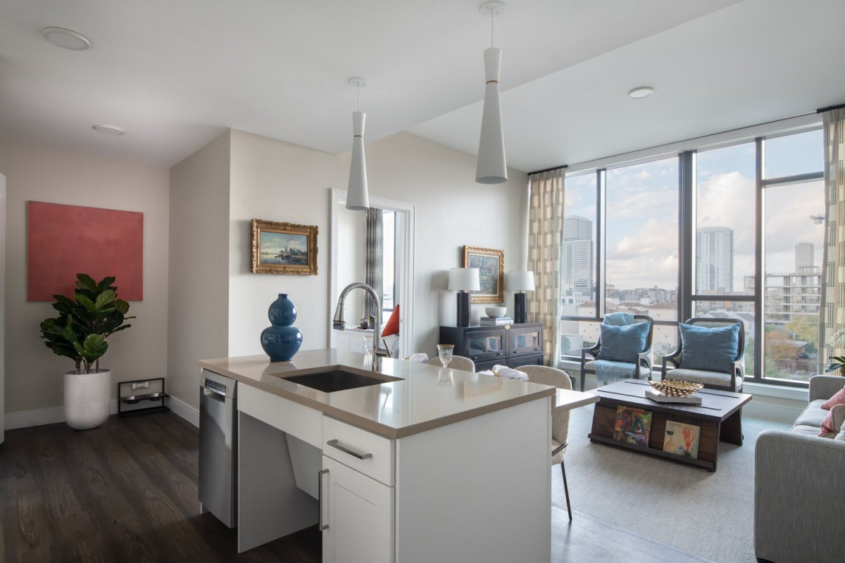 A modern open-concept apartment with a bright kitchen and living area.