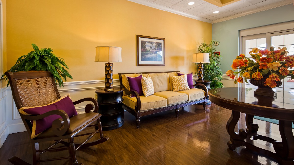 A cozy living room with a yellow sofa, decorative pillows, and elegant furnishings.
