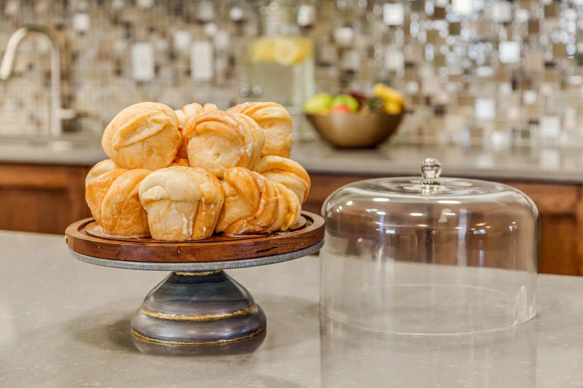 A display of freshly baked muffins on a cake stand in the kitchen.