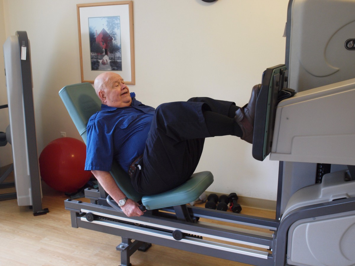 A person using a leg press machine in a gym setting.