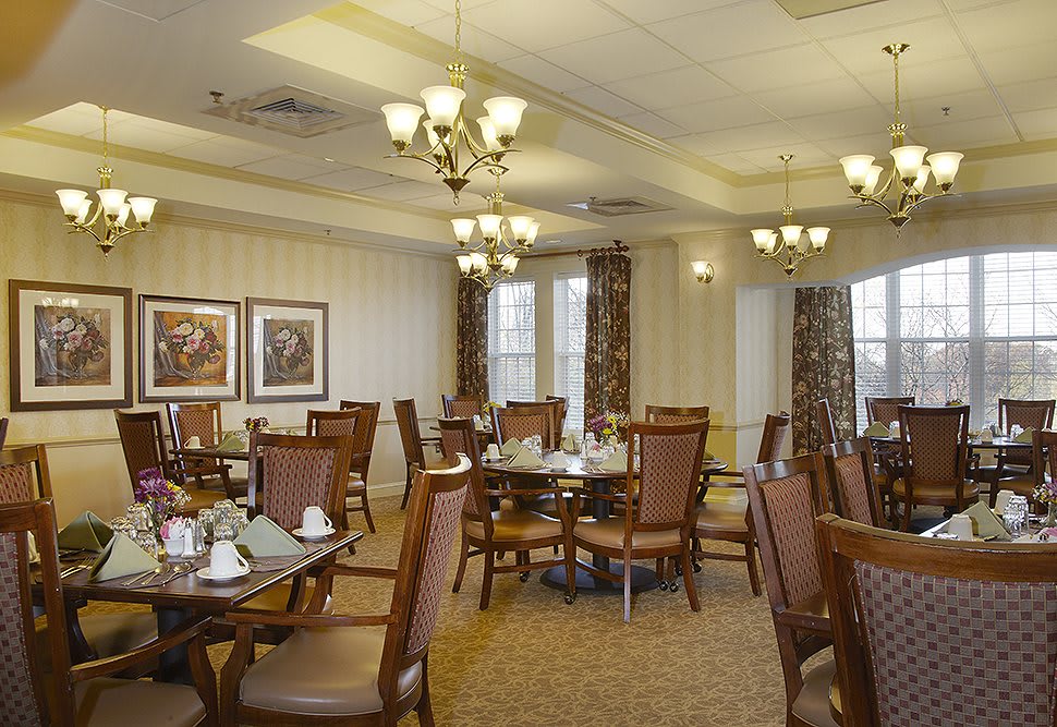 A well-decorated dining room with elegant chandeliers and neatly arranged tables.