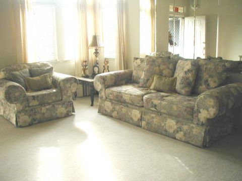 A bright living room featuring a floral-patterned sofa and armchair.