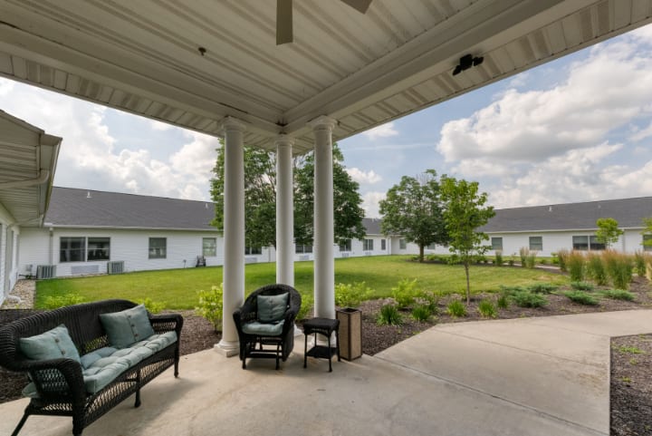 A cozy patio with outdoor seating and a garden view on a sunny day.
