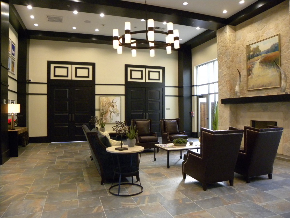 A modern lobby with stylish furniture and a central chandelier.