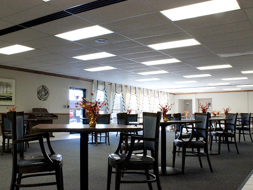 A spacious and well-lit dining room featuring tables arranged for a comfortable gathering.