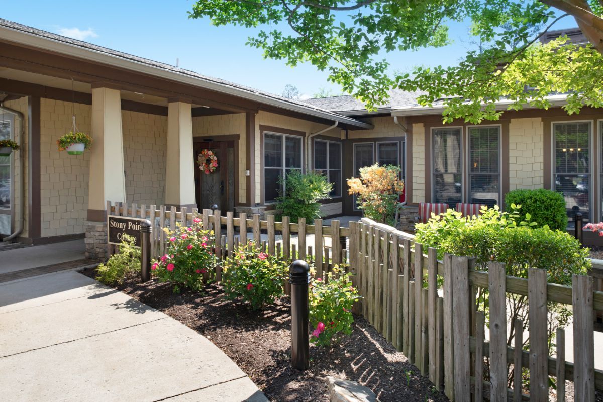 A charming house with a garden and wooden fence on a sunny day.