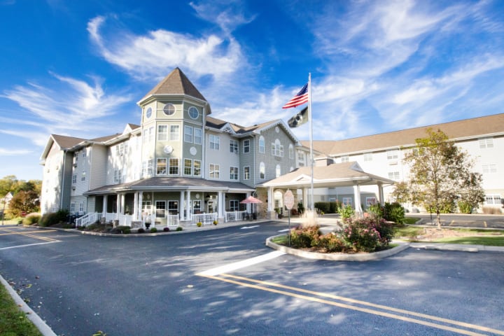 A picturesque hotel with flags, set against a vibrant blue sky.