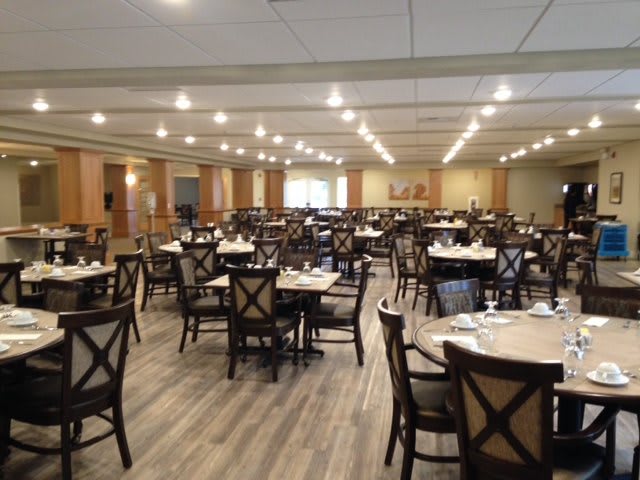Empty dining hall with neatly arranged tables and chairs.