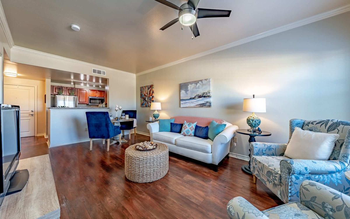 A cozy living room with modern decor, featuring a white sofa, a round coffee table, and an adjacent dining area.