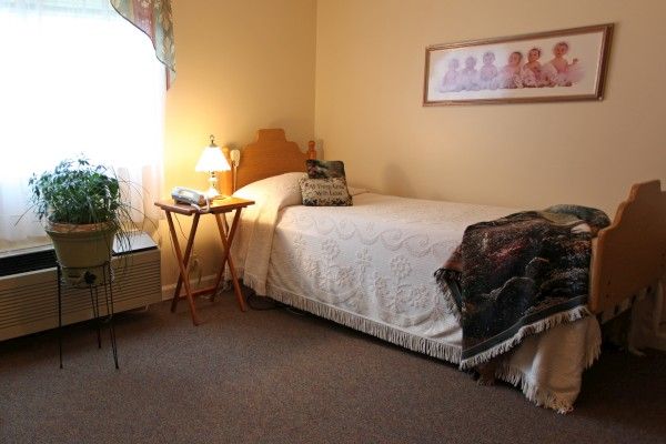 A cozy bedroom with a single bed and soft lighting.