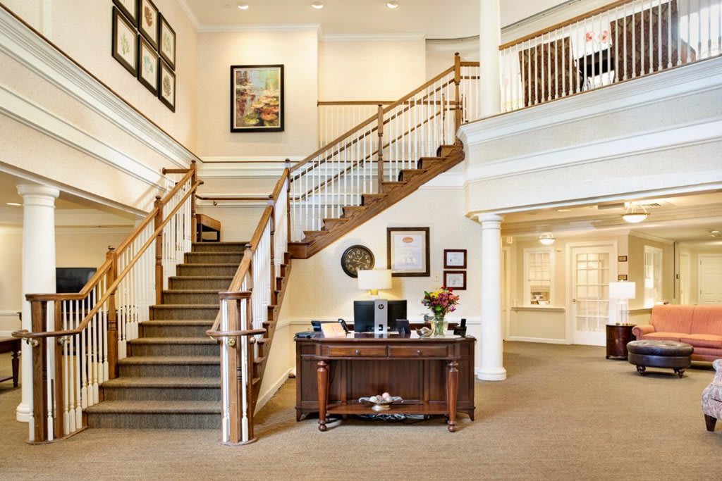 A spacious lobby with a central staircase and welcoming desk.