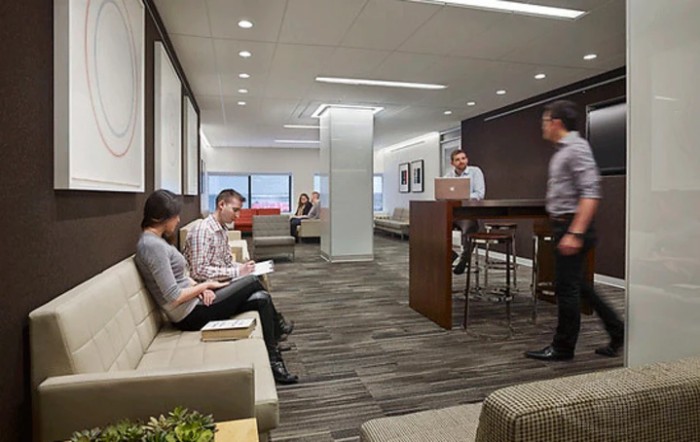 A modern office lobby with people working and waiting.