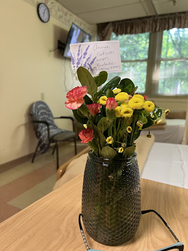 A vibrant bouquet of flowers in a decorative vase, accompanied by a heartfelt note.