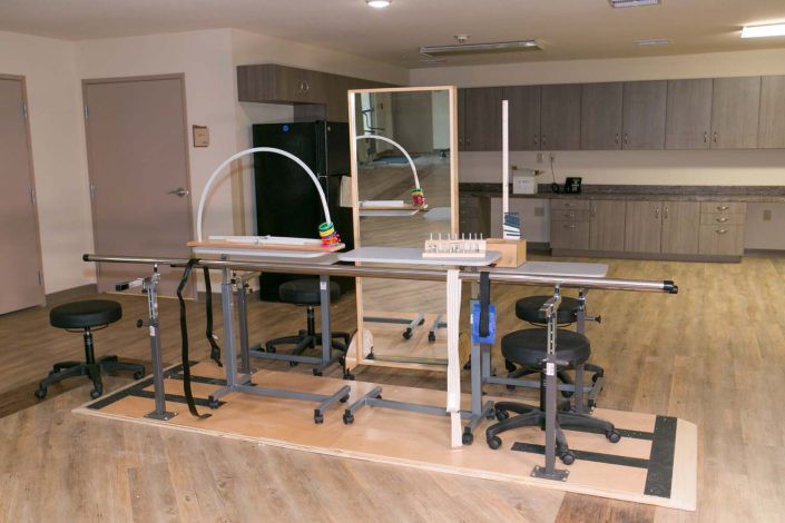 A rehabilitation room equipped with parallel bars and other therapy equipment.