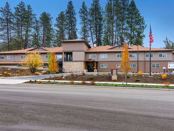 A modern building surrounded by trees, located beside a road in a scenic outdoor setting.