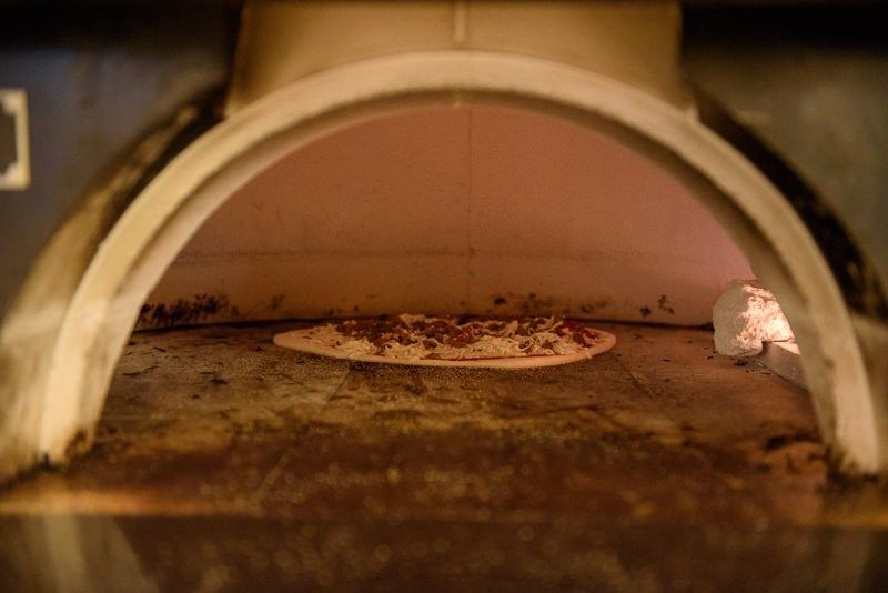 A pizza baking inside an oven.
