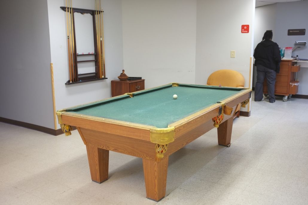 A billiard table in a game room setting.