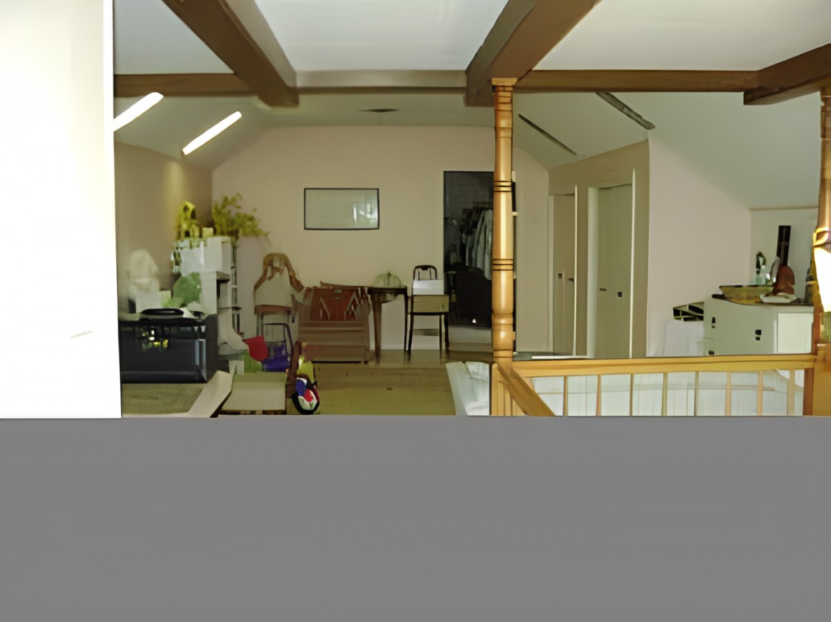 An office space with a desk, computer, and decorative items in a hallway setting.