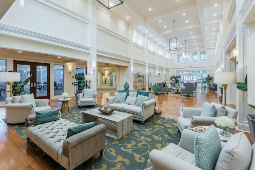 A bright and spacious lobby designed with modern furnishings and lush greenery, creating a welcoming atmosphere.