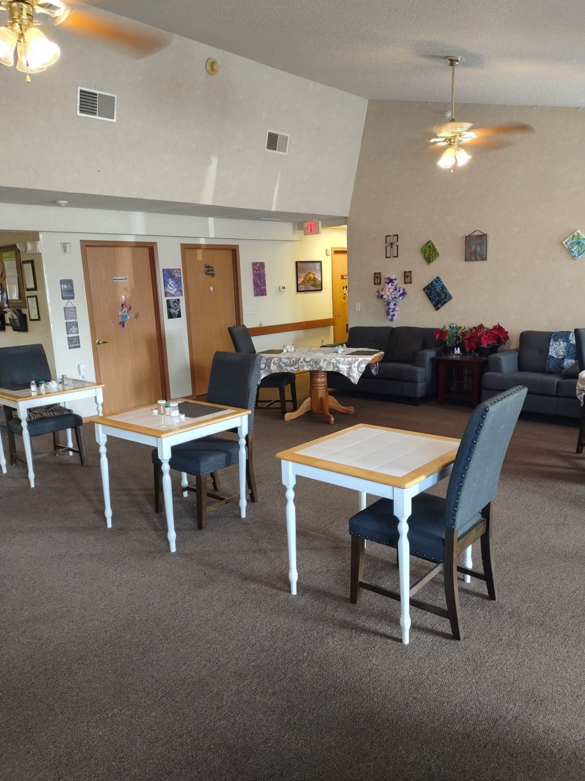 A cozy dining and lounge area with tables, chairs, and wall decorations.