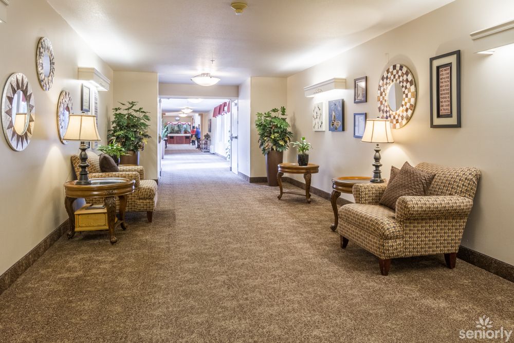 A well-lit hallway featuring comfortable seating and decorative elements.