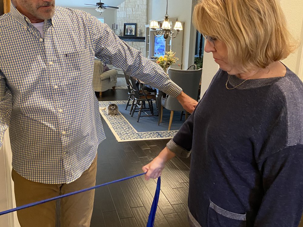 Two people using a tape measure indoors.