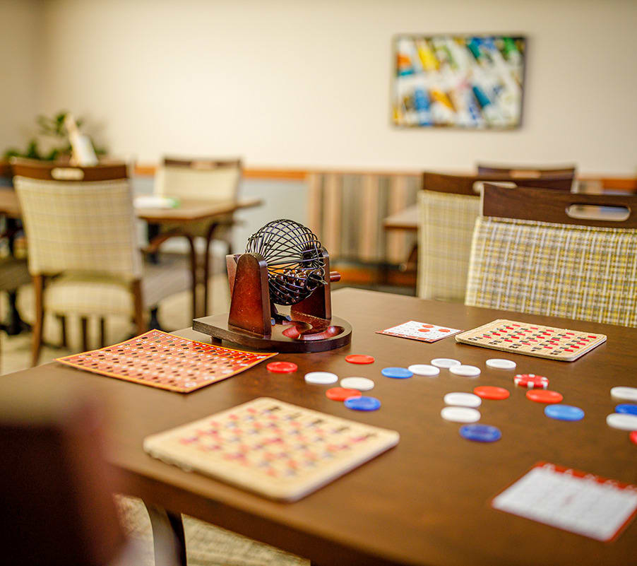 A cozy game room set up with bingo cards, chips, and a bingo machine on a table.