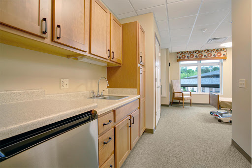 A cozy kitchen area featuring wooden cabinets and a view outside.