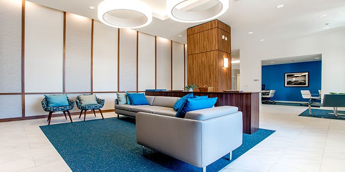 A modern lobby with stylish seating and circular ceiling lights.