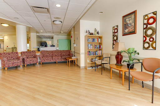 A cozy and inviting waiting area featuring comfortable seating and a bookshelf.