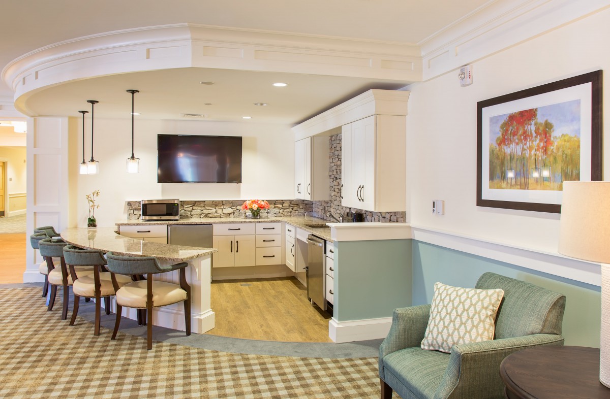 A cozy and modern kitchen with an adjacent living area, featuring stylish furniture and appliances.