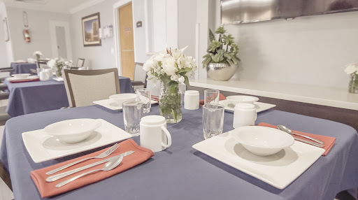 A beautifully arranged dining table with a floral centerpiece, ready for a meal.