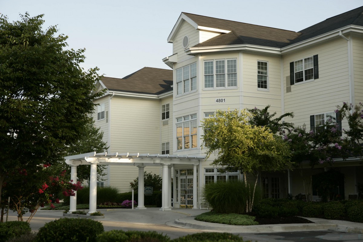A multi-story residential building with a welcoming front entrance and landscaped surroundings.
