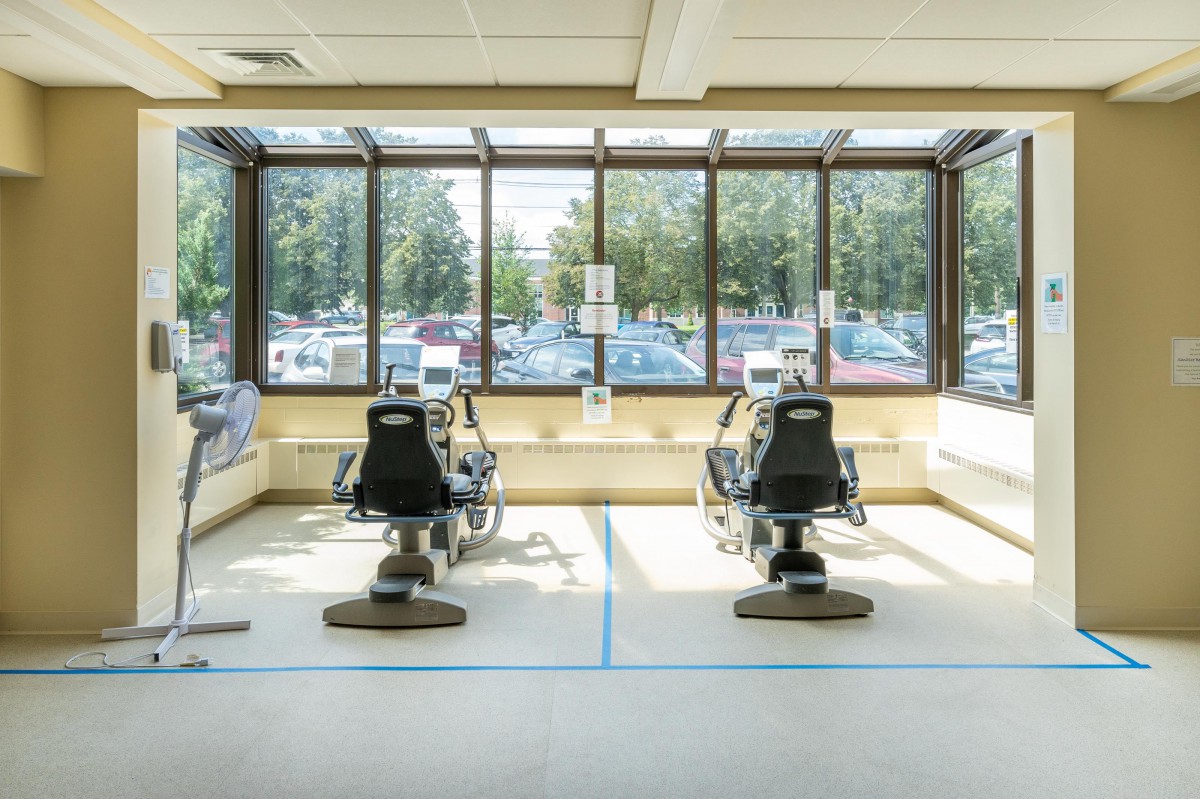 A modern dental office waiting area with chairs and large windows allowing natural sunlight.