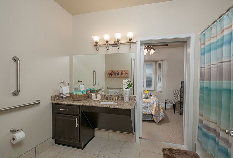 A modern bathroom with a large mirror and elegant lighting.