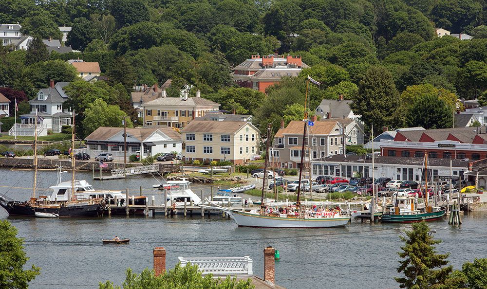 A picturesque coastal town with a harbor full of boats and charming waterfront buildings.