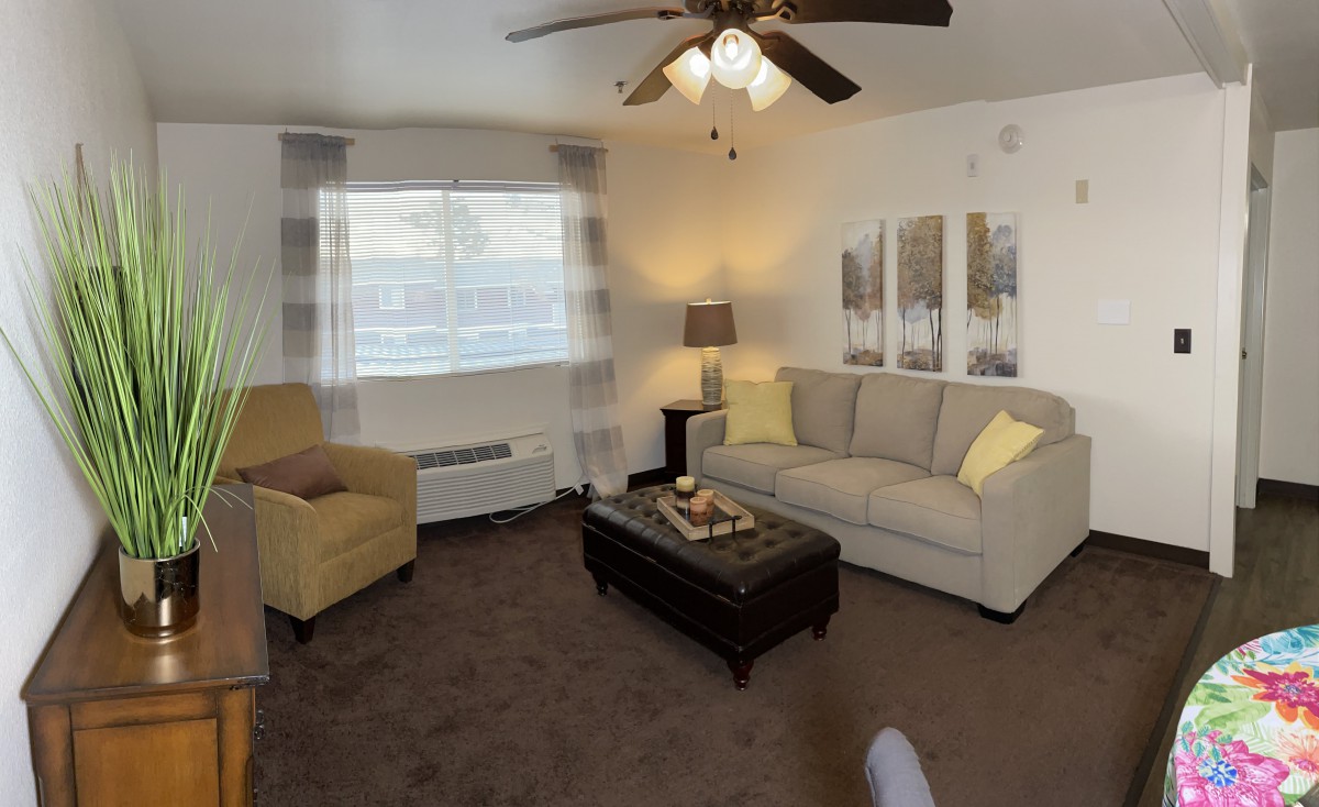 A cozy living room with a sofa, armchair, and coffee table.