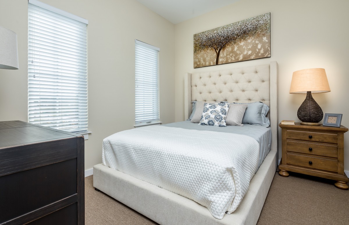 A modern bedroom with a stylish bed and elegant decor.