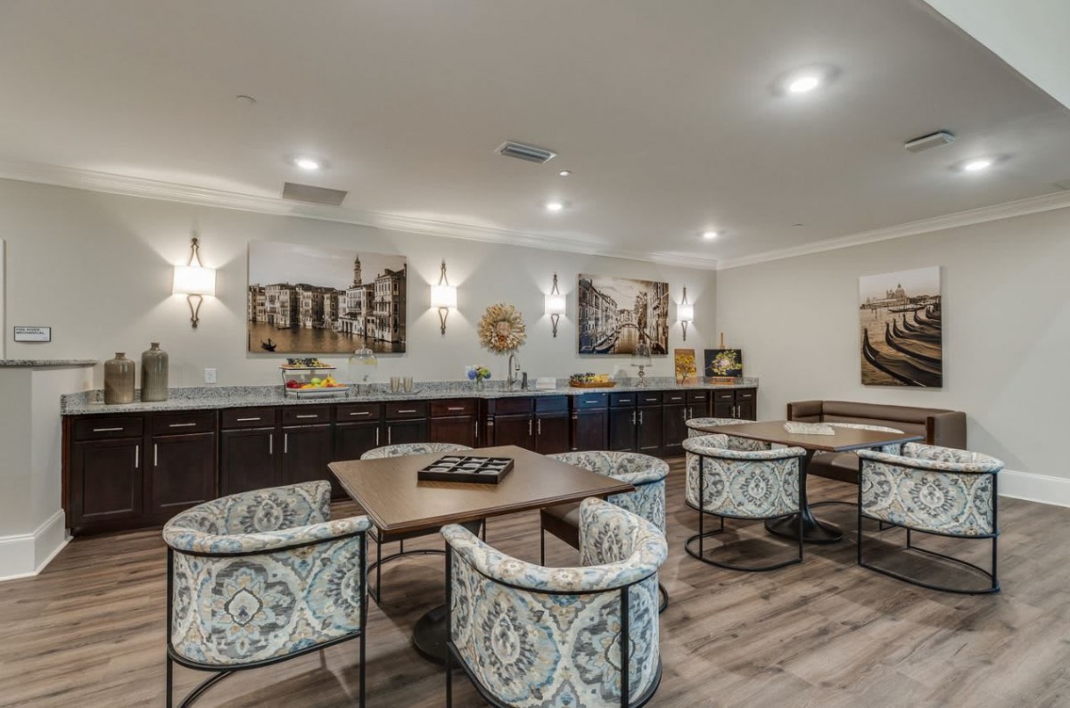 A modern dining area featuring stylish chairs, contemporary artwork, and elegant lighting.