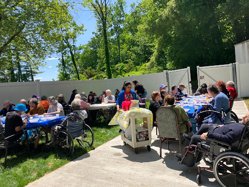A sunny outdoor gathering where people enjoy refreshments at tables.