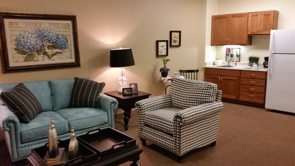 A cozy living room with a sofa and armchair, featuring stylish decor and soft lighting.