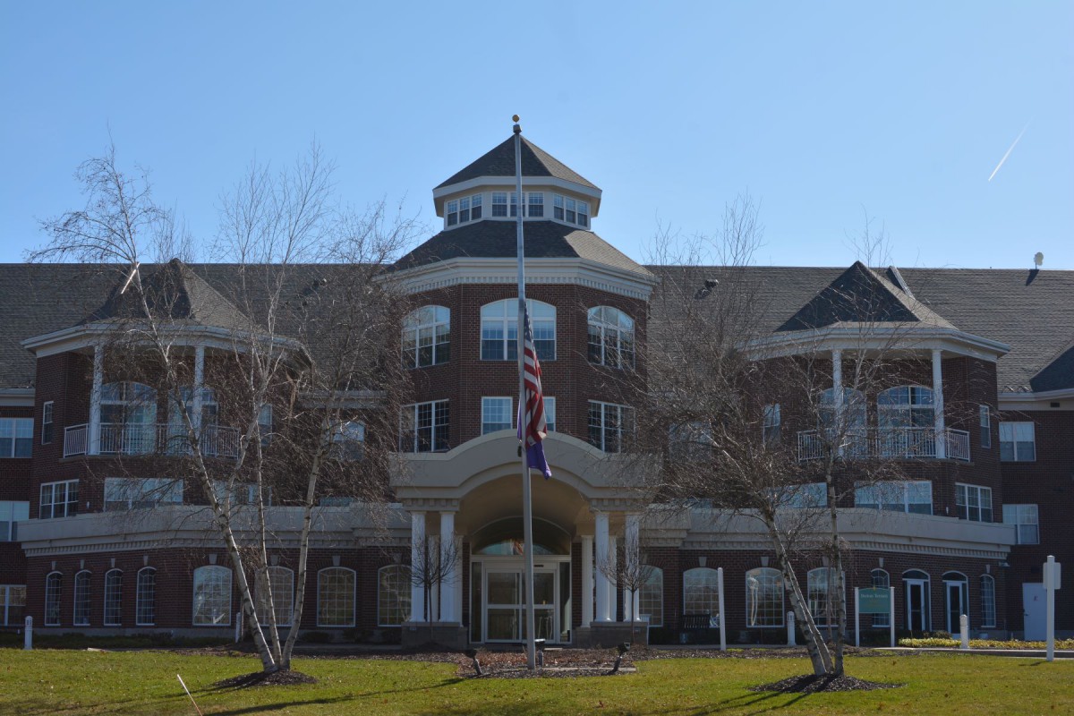 A symmetrical government building with flags in front, captured on a clear day.