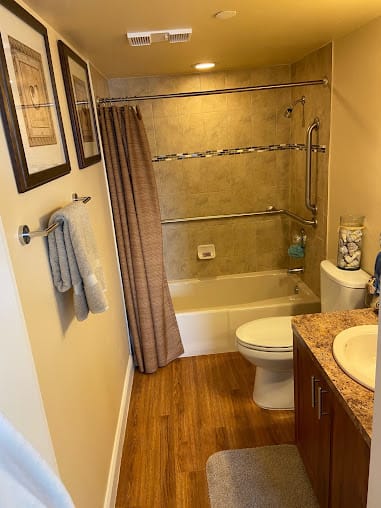 A neatly arranged bathroom with a shower-tub combination and contemporary decor.