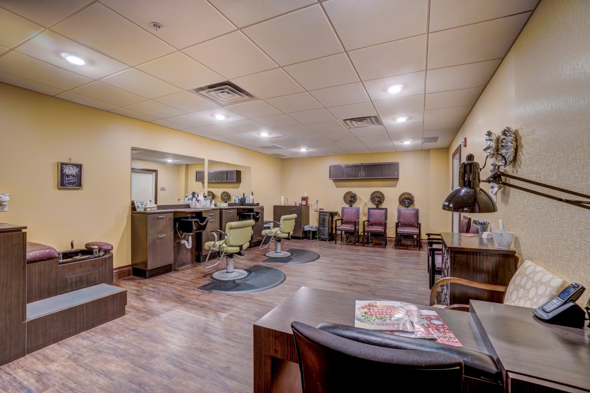 A spacious beauty salon with styling stations and a waiting area.