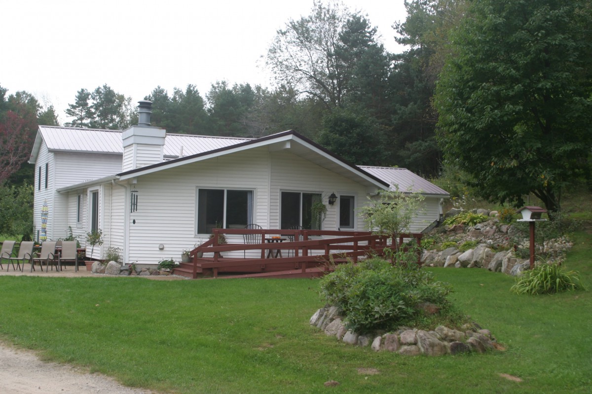 A cozy house surrounded by lush greenery and a well-maintained lawn.