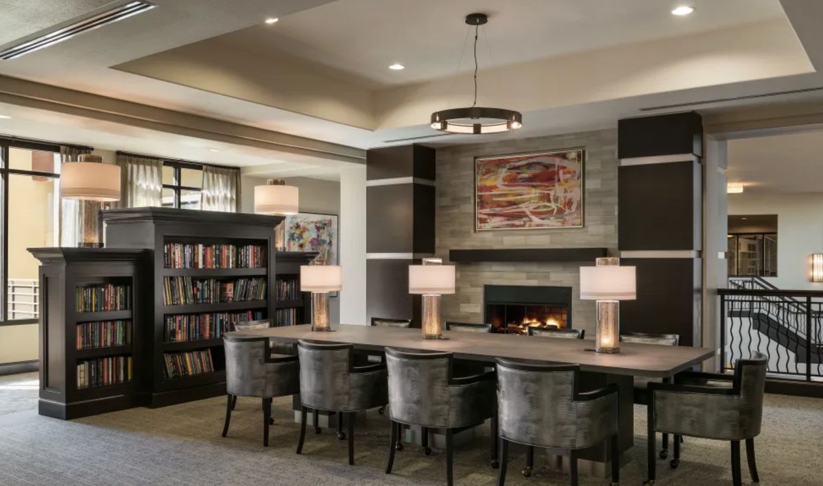 Modern library interior with a fireplace and reading area.
